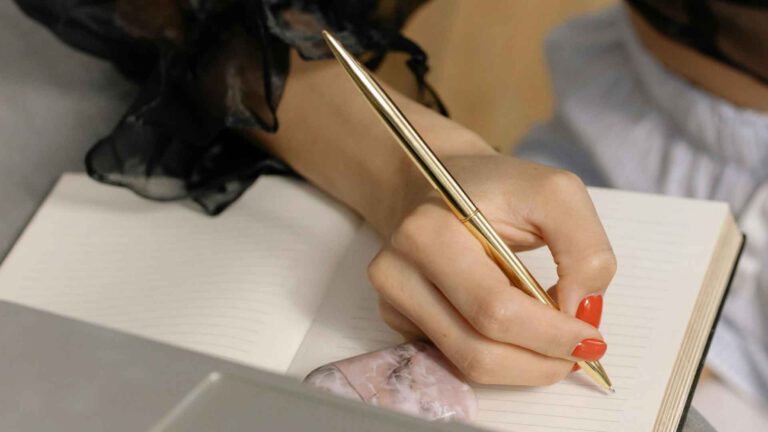 Journaling: Schreib dich frei von Kummer und Sorgen, Hand einer Frau, die schreibt